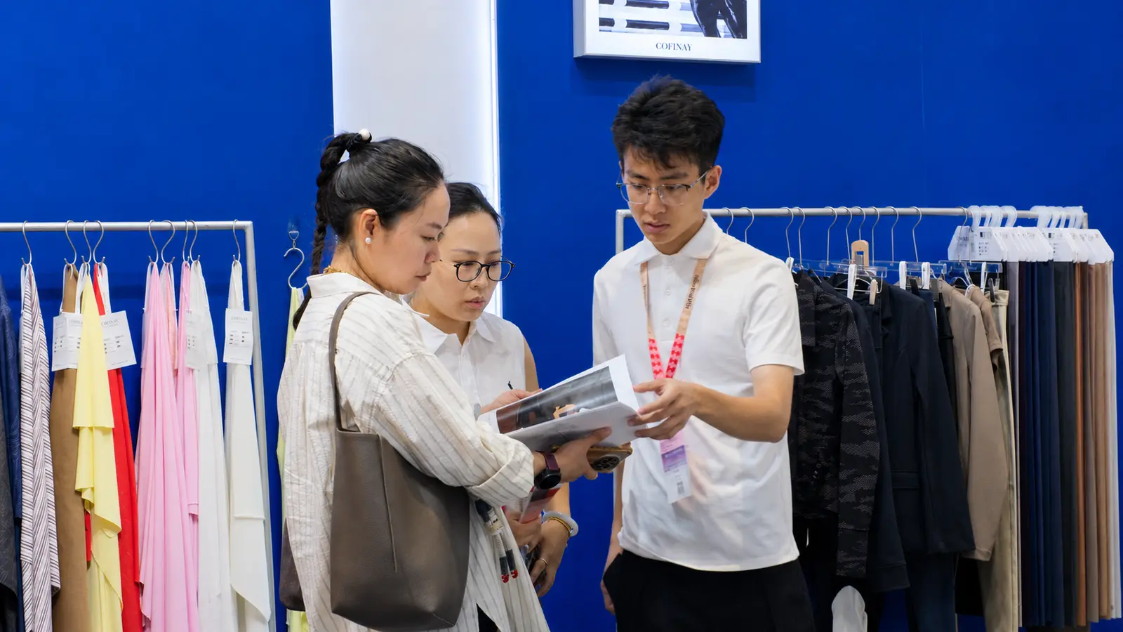 Cofinay team member introducing activewear fabric options to visitors at Intertextile Shanghai Apparel Fabrics 2026.